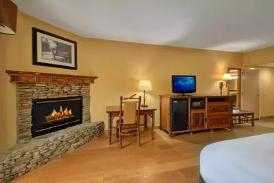 Fireplace next to a desk and tv stand