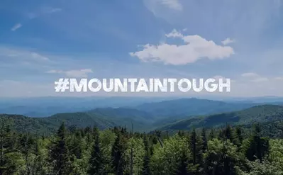 mountaintough logo with the smoky mountain behind it