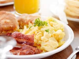 scrambled eggs, bacon, and biscuits on plate
